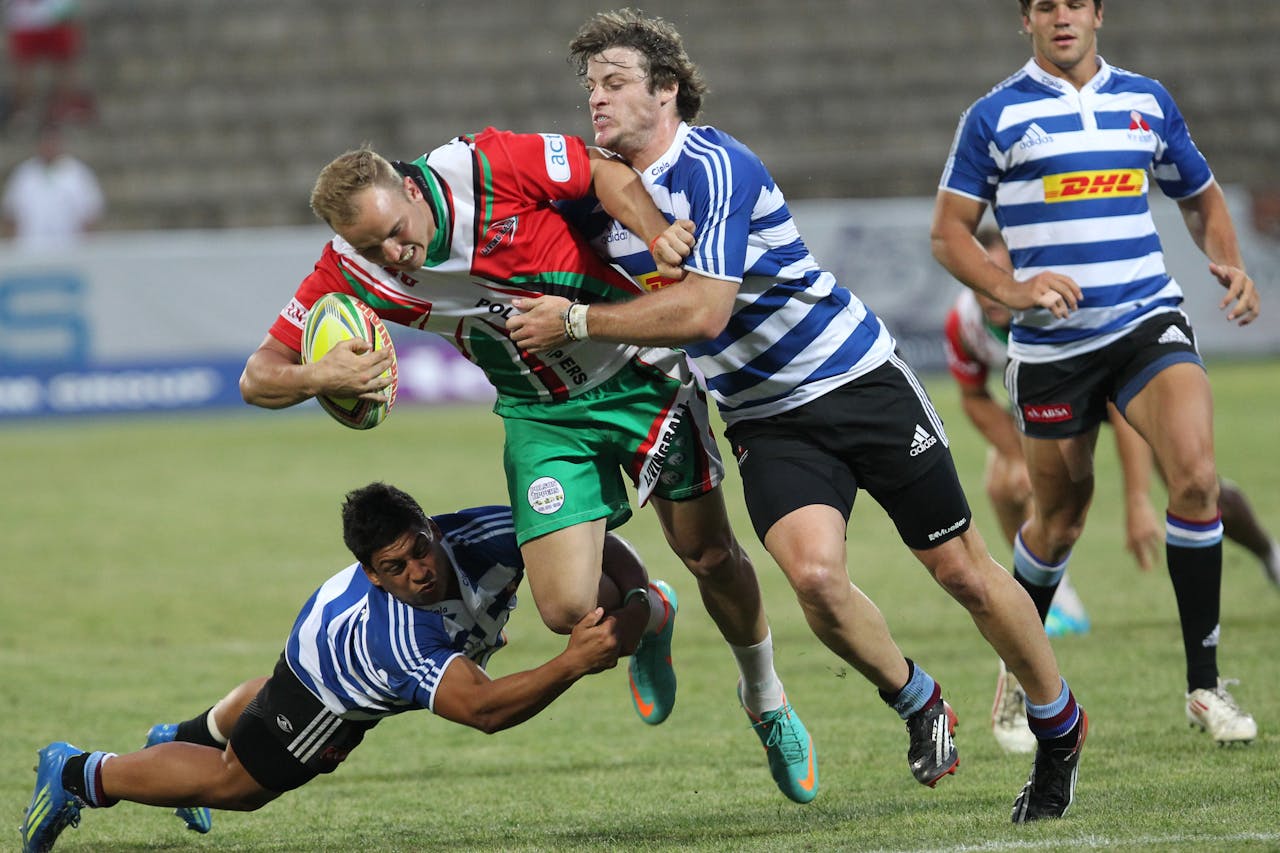 our-story Dynamic action shot of rugby players in a fierce tackle during a lively outdoor game.