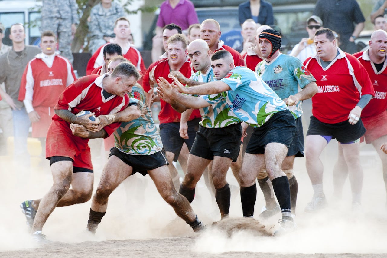 who-we-are A competitive rugby match showcasing teamwork, athleticism, and dynamic action on a dusty field.